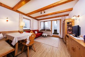 ein Wohnzimmer mit einem Tisch und einem roten Sofa in der Unterkunft Alpenglühn in Reit im Winkl