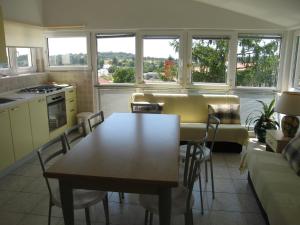 een keuken en een woonkamer met een tafel en stoelen bij Apartman f1 in Pula