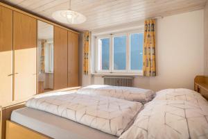 a bedroom with two beds and a window at Wohnung Kanisfluhblick in Bizau