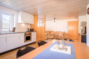 ビザウにあるWohnung Kanisfluhblickのテーブルと椅子のあるキッチンとダイニングルーム