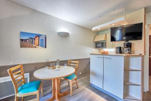 a kitchen with a table and chairs in a room at Résidence Pierre & Vacances Les Tamaris in Trouville-sur-Mer