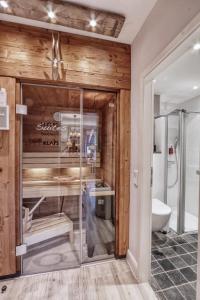 ブラウンラーゲにあるHOME Suites Deluxe mit Saunaのバスルーム(ガラス張りのシャワー、トイレ付)