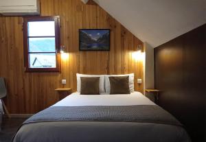 a bedroom with a large bed with a window at Hôtel de la Gare in Pierrefitte-Nestalas