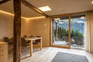 a dining room with a table and a large window at Ferienhaus im Stadl in San Martino