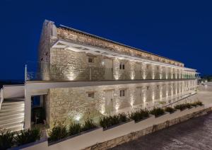 a large stone building with plants on the side at Aliv stone suites & spa in Agios Nikolaos