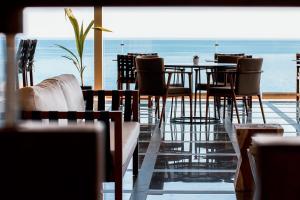 a restaurant with tables and chairs and a view of the ocean at Aliv stone suites & spa in Agios Nikolaos