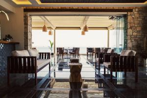 a restaurant with tables and chairs and a view of the ocean at Aliv stone suites & spa in Agios Nikolaos