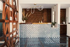 a bathroom with a blue tiled wall and a chandelier at Aliv stone suites & spa in Agios Nikolaos
