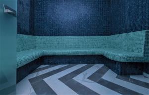 a bathroom with a tub with green tiles at Aliv stone suites & spa in Agios Nikolaos