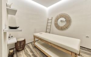 a white room with a bed and a mirror at Aliv stone suites & spa in Agios Nikolaos