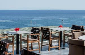 a table and chairs on a balcony with the ocean at Aliv stone suites & spa in Agios Nikolaos