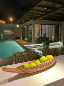 uma tigela de maçãs sentada numa mesa ao lado de uma piscina em ViaSul Motel em Ceilândia