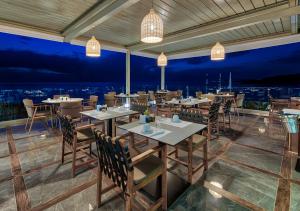 a restaurant with tables and chairs with a view at Aliv stone suites & spa in Agios Nikolaos