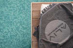 a towel sitting on top of a table next to a green cloth at Aliv stone suites & spa in Agios Nikolaos