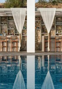 a view of the pool at a resort with its reflection in the water at Aliv stone suites & spa in Agios Nikolaos