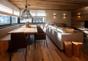 a living room with a couch and a table and chairs at Nova Gosta Montafon NEU in Gaschurn