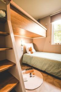 a small room with two bunk beds and a table at Camping Le Royan in Royan