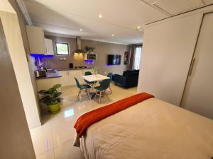 a bedroom with a bed and a kitchen and a table at ARCHITECTS VIEW - VIP FAMILY SUITE in Durban