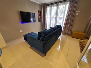 ein Wohnzimmer mit einem Sofa und einem TV in der Unterkunft ARCHITECTS VIEW - VIP FAMILY SUITE in Durban