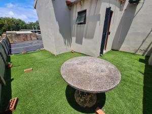 a round table in a yard with a green lawn at ARCHITECTS VIEW - VIP FAMILY SUITE in Durban