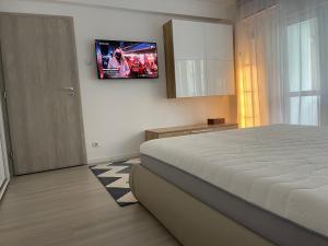 a bedroom with a bed and a television on the wall at Start Apartments 2 in Bucharest +32 photos