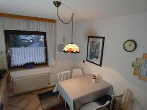 comedor con mesa y reloj en la pared en Ferienhaus Sommerhaus-Sauerland, en Hachen