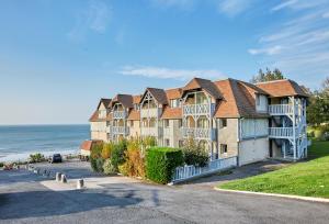 uma fila de casas com o oceano ao fundo em Résidence Pierre & Vacances Les Tamaris em Trouville-sur-Mer