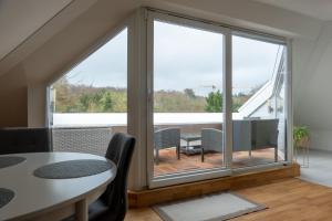 Zimmer mit einem großen Fenster mit einem Tisch und Stühlen in der Unterkunft Wohnung mit einer Sauna direkt am Park in Wiesbaden