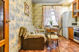 a small kitchen with a table and a refrigerator at Mytninskaya 2.1 in Saint Petersburg