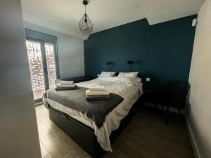 a bedroom with a large bed with a blue wall at Atico Bremadito in Torrox Costa