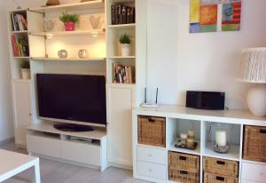 ein Wohnzimmer mit einem großen weißen Entertainment-Center mit Fernseher in der Unterkunft Vista Marina - 2 bedrooms sleeps 4 in La Herradura