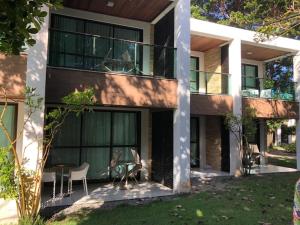 a house with a balcony and a table and chairs at ILOA RESIDENCE L202 in Barra de São Miguel