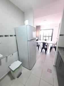 a kitchen with a refrigerator and a table with chairs at Home Zafiro I in Santa Fe +1 photo
