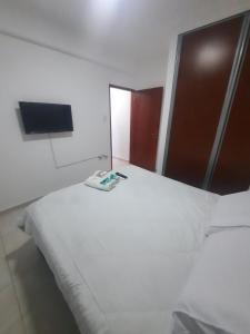 a bedroom with a large white bed and a flat screen tv at Home Zafiro I in Santa Fe