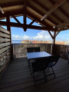a table on a deck with a view of the ocean at LES 12 DE LARROS in Gujan-Mestras