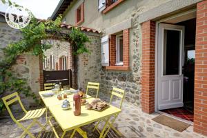 einen gelben Tisch und Stühle auf einer Terrasse in der Unterkunft Chambres d'Hôtes Ondine et Igor in Saint-Marcellin-en-Forez