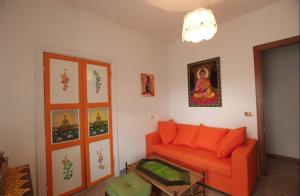 salon z pomarańczową kanapą i obrazem w obiekcie Da Marco Casa Vacanze Borgo Civita - ID 6678 CIN w mieście Trevi nel Lazio