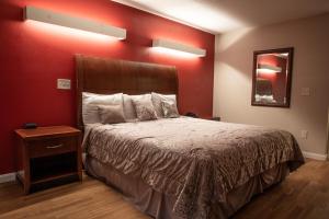 een slaapkamer met een bed en een rode muur bij Classic Motor Lodge Providence - West Greenwich in West Greenwich
