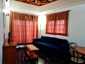 a living room with a blue couch and a table at Viviendas Vacacionales Escuela in Agulo