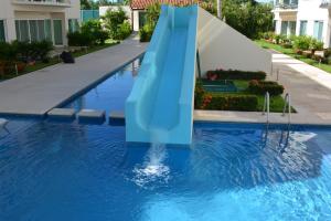 um escorrega de água azul numa piscina em Hermoso y confortable departamento. em Ixtapa