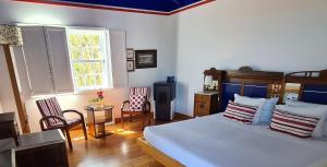 a bedroom with a bed and a table and chairs at Quinta da Meia Eira in Horta