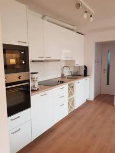 cocina con electrodomésticos blancos y suelo de madera en Living City, apartament cu două dormitoare, en Sibiu