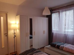 1 dormitorio con un gran armario blanco y una ventana en Living City, apartament cu două dormitoare, en Sibiu