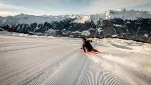 a person is skiing down a snow covered mountain at Hotel Silvapina in Klosters
