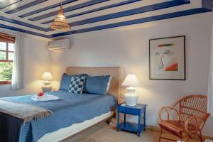 1 dormitorio con 1 cama y techo azul en Pousada Blanca Mar en Búzios