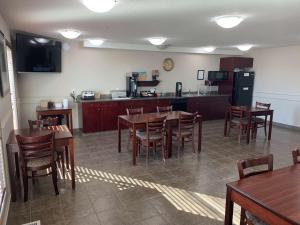 a restaurant with tables and chairs and a kitchen at SureStay Hotel by Best Western Bassano in Bassano