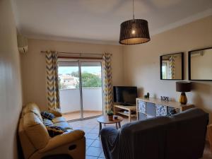 a living room with a couch and a tv at Jardim Paraiso Guia in Guia