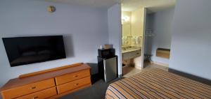 a hotel room with a bed and a flat screen tv at Lakeview Inn & Suites Okeechobee in Okeechobee