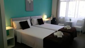 a hotel room with two beds and a window at Pensión Mar Azul in Santiago de Compostela