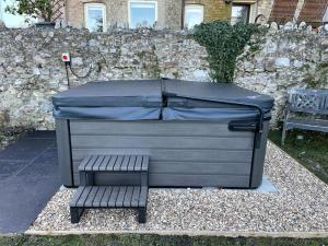 a grill with a bench next to a stone wall at Silver View-Spa Hot Tub-Beautiful Sea Views-Free Parking- Central Lyme Regis in Lyme Regis